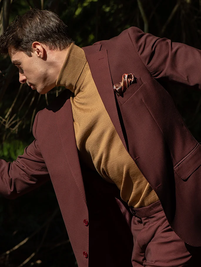 Giacca monopetto con tessuto lavorato fantasia, camicia bianca di cotone, dettaglio fazzoletto da taschino in seta, fantasia geometrica.