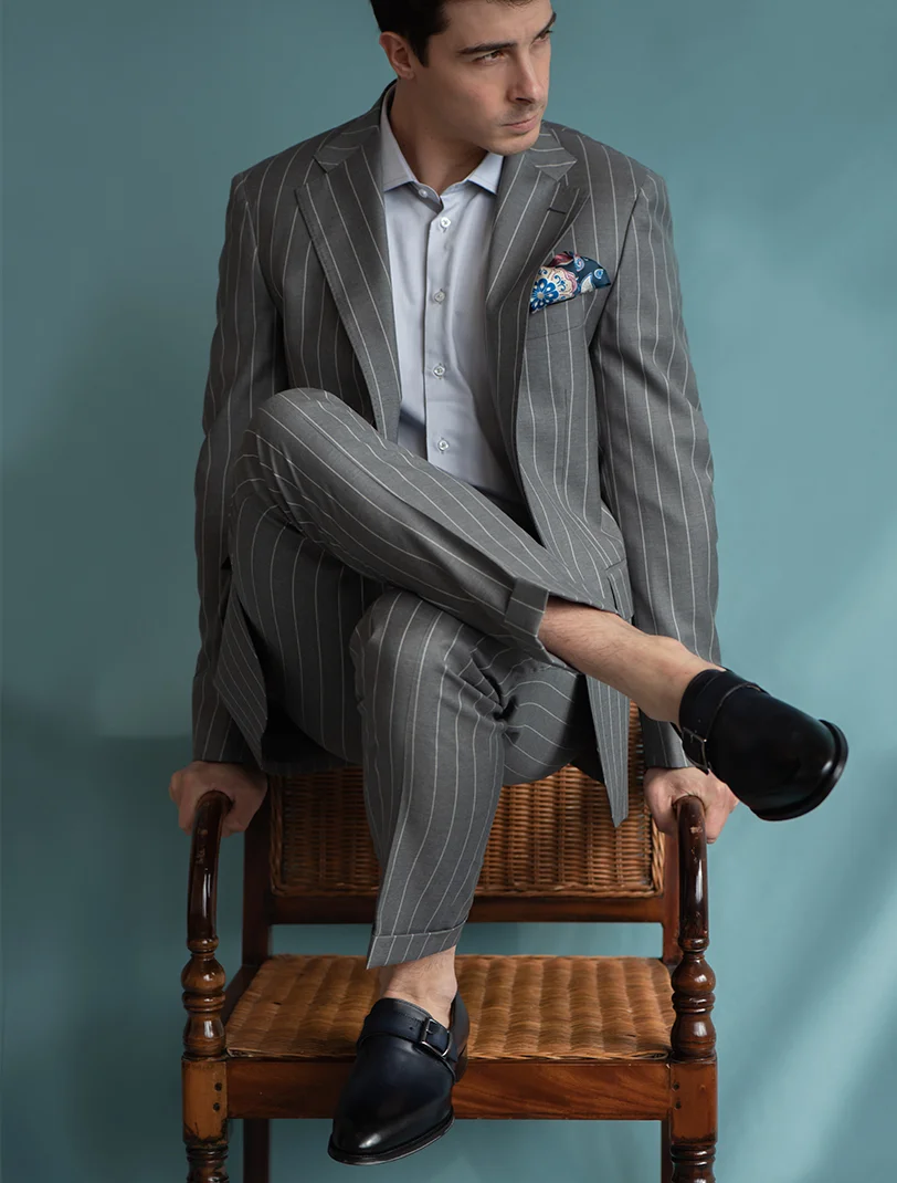 Pantalone sartoriale con pince, vita alta, regolatori e doppia allacciatura con bottoni. Tessuto lana.