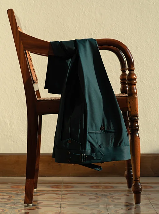 Pantalone sartoriale con pince, vita alta, regolatori e doppia allacciatura con bottoni. Tessuto lana.